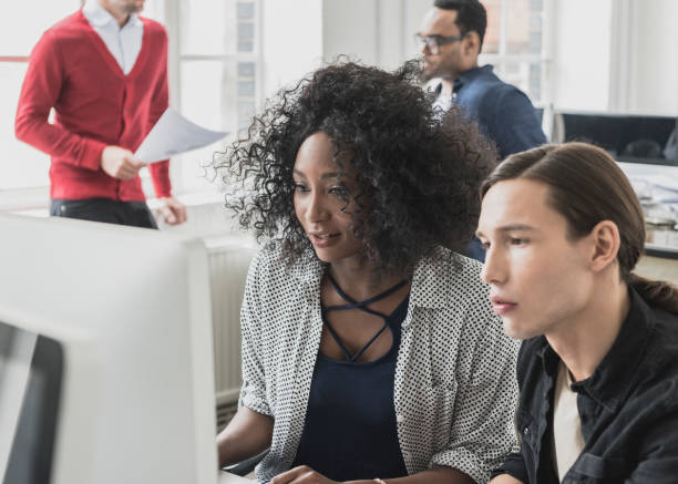 istock Female manager training young male colleague on office computer 862378608