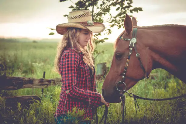 Country Girl lovingly spends quiet moment with her horse early summer morning