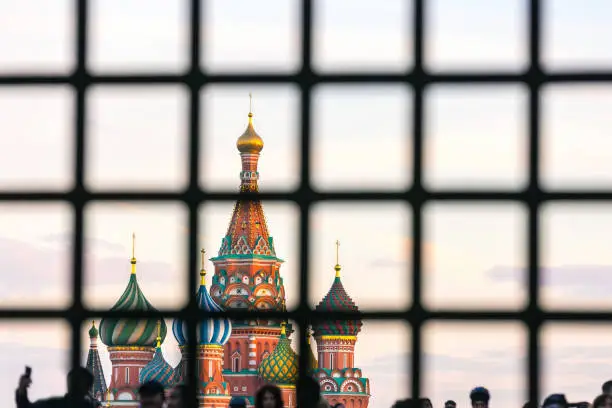 St. Basil's Cathedral on Red Square with a large number of people is hidden behind bars.