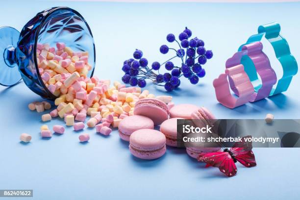 Marshmallow And Macaroons Pouring Out Of Jars Blue Background Stock Photo - Download Image Now