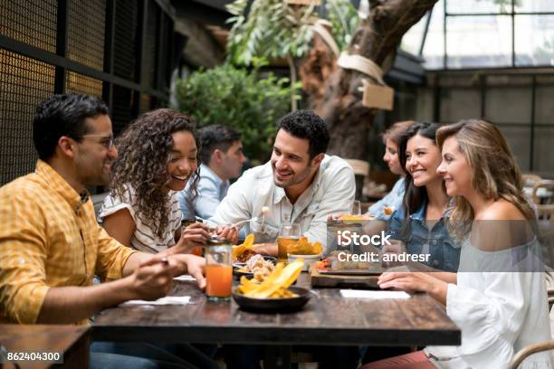 Happpy Group Of Friends Having Dinner Together At A Restaurant - Fotografias de stock e mais imagens de Restaurante