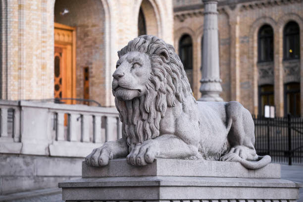 Stone lion Stone lion on the background of the parliament in Oslo. Norway stortorget stock pictures, royalty-free photos & images