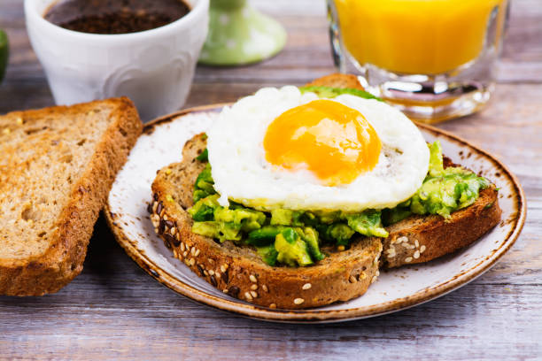 Avocado egg sandwich with whole grain bread Avocado egg sandwich with whole grain bread on wooden background. Copy space appetizer plate stock pictures, royalty-free photos & images
