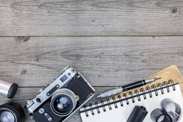istock retro camera, lenses, negative  film and empty notebook on gray wooden table 862411902