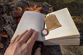 open book with vintage bookmark and womans hand