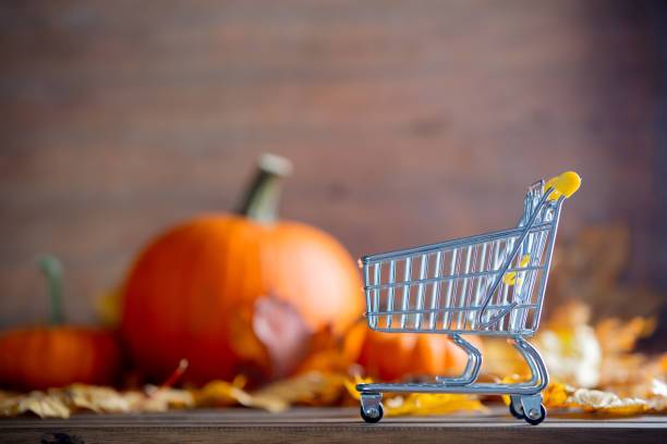 maple leaves and pumpkins with supermarket cart stock photo
