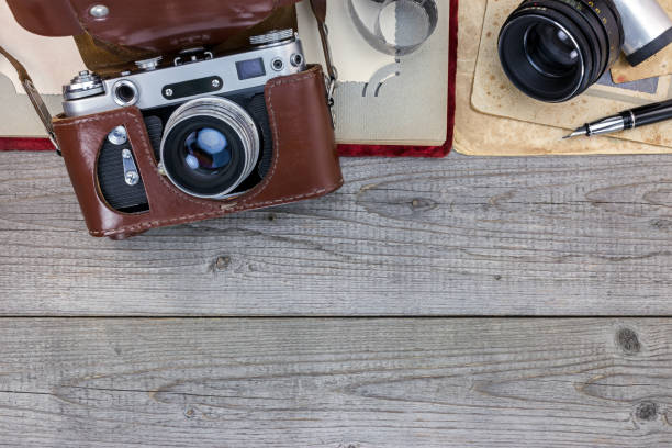 old still camera in leather case, photo album and old pictures on wooden desk old still camera in leather case, photo album and old pictures on wooden background old black leather photo album stock pictures, royalty-free photos & images