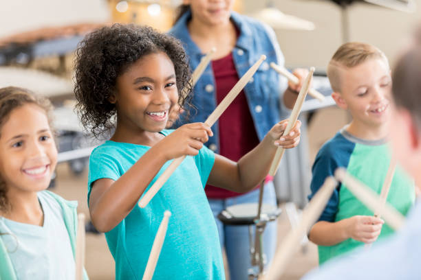 schülerinnen und schüler lernen, percussion-instrumente zu spielen - music lessons stock-fotos und bilder