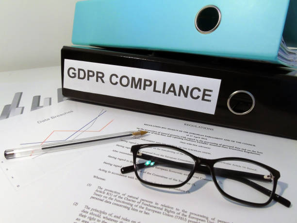 General Data Protection Regulation (GDPR) Compliance Lever Arch Folders on Desk with Documents (Legislative Text and Graphs), Glasses and Pen