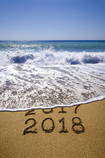 istock New year 2018 and 2017 on sandy beach with waves 862423838