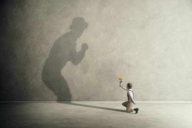 Man on knees with flowers making peace with his shadow