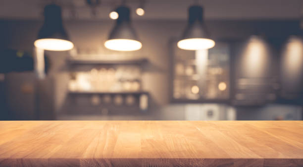 istock Wood table on blurred of counter cafe with light bulb 862429776
