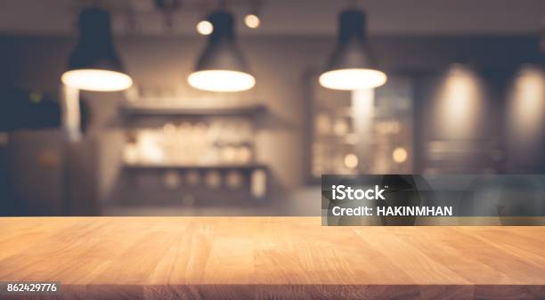 Wood Table On Blurred Of Counter Cafe With Light Bulb Stock Photo - Download Image Now