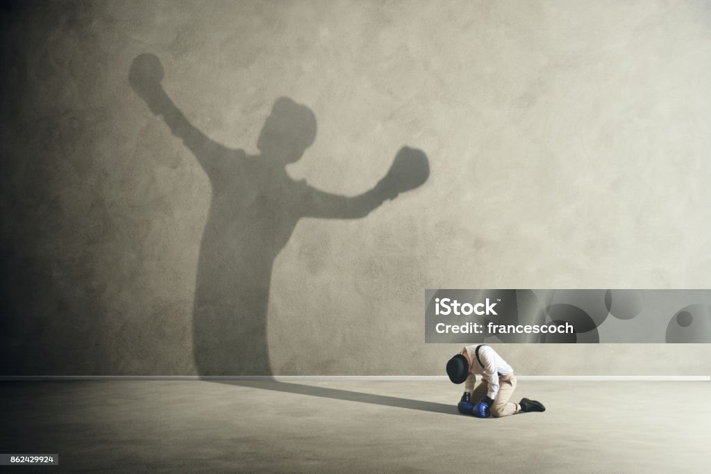 man defeated by his shadow boxing Defeat Stock Photo