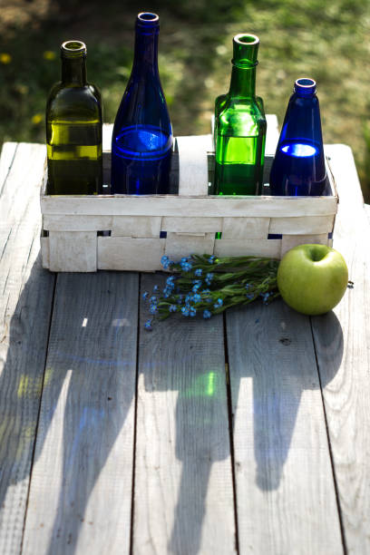 Four bottles of drinks in a white basket on the white table
