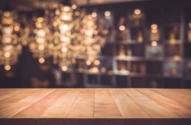 Wood table on blur cafe (restaurant) background Empty of wood table top with blurred light gold bokeh abstract background.For montage product display or design key visual layout food court photos stock pictures, royalty-free photos & images