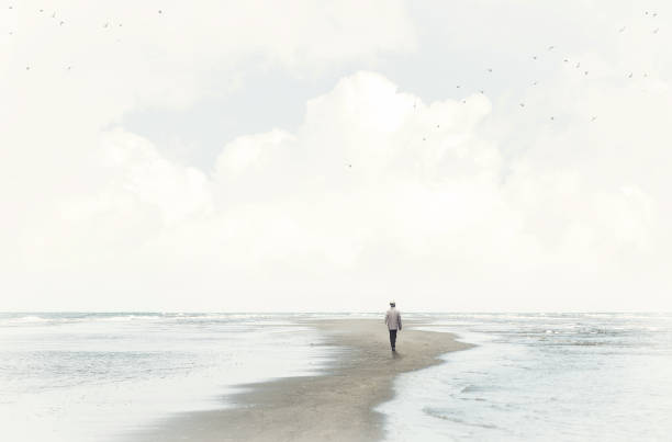 calm man walking in the sand between two seas stock photo