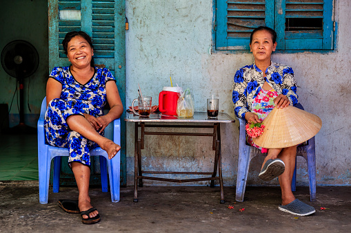 Dos vietnamitas mujeres tomando café juntos, Delta del río Mekong, Vietnam photo