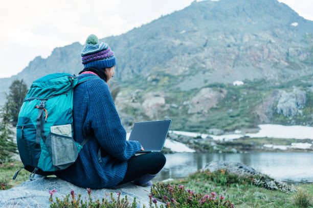 istock Woman using laptop in the wild 862449534