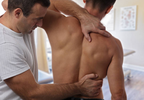 istock Chiropractic back adjustment. Muscular Man suffering from back and neck pain. 862452736