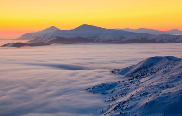 istock The landscape with a stunning sunset, interesting thick fog and mountains covered with textured snow on a winter day. Fantastic winter scenery. 862453068