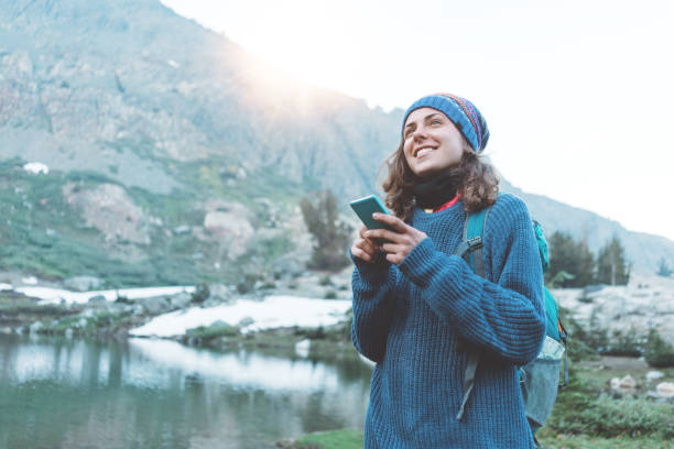 istock Happy traveler typing and chatting on the mobile phone in wilderness 862454038