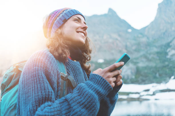 istock Happy traveler typing and chatting on the mobile phone in wilderness 862454048