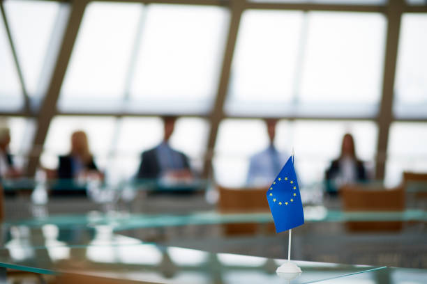 European flag on board table Meeting of European Union in conference room with glassy round table summit meeting photos stock pictures, royalty-free photos & images
