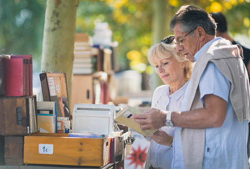 Mature couple buying books at the flea market in the old european city center
