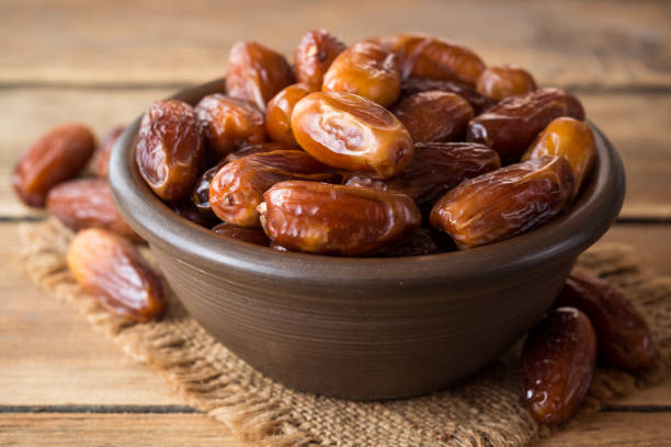 istock Dried dates fruit in ceramic bowl on wooden table. 862461724