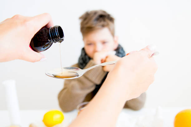 boy tener gripe - jarabe para la tos fotografías e imágenes de stock