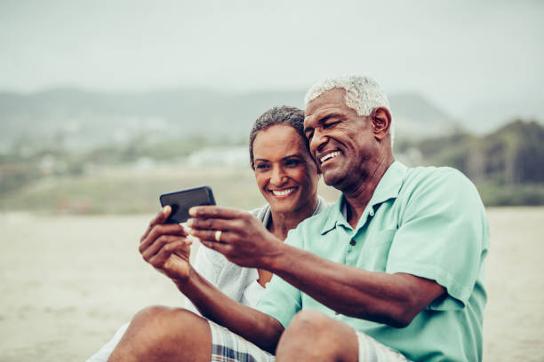 istock Senior couple having fun taking selfie on beach 862473468