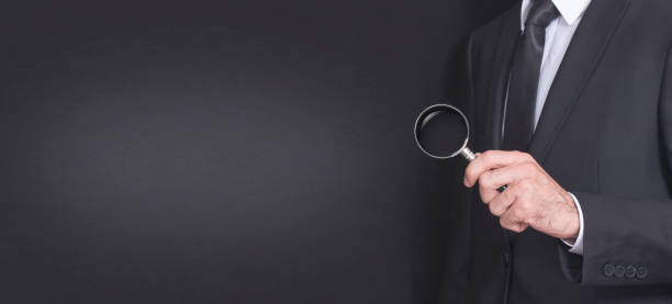 istock suit businessman holding a magnifying glass 862478070