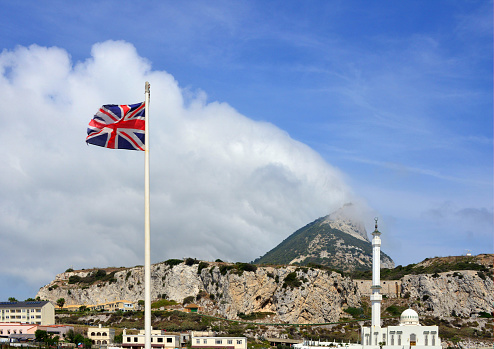 Gibraltar: Union Jack and the Sunni Mosque of The Custodian of the The Holy Mosques, Europa Point - aka Ibrahim-al-Ibrahim Mosque and King Fahd bin Abdulaziz al-Saud Mosque - cliffs and peak in the background - photo by M.Torres