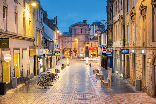 Stock photograph of a street with storefronts in downtown Inverness, Scotland, United Kingdom.