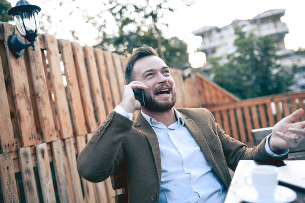 istock Young Smiling Businessman Working on Balcony Talking on the Phone and Drinking Cafe 862507692