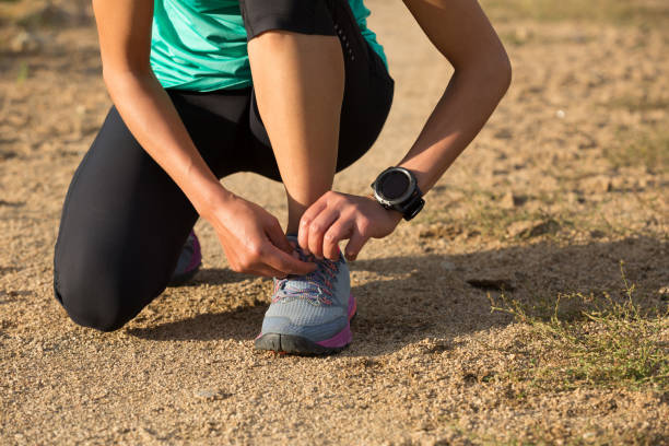 istock woman runner tying shoelace on dirt road 862511260