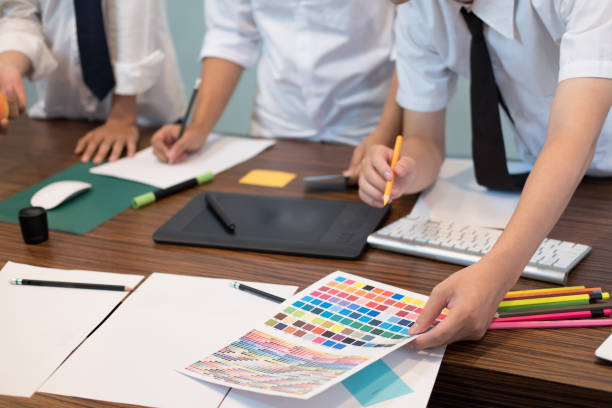 istock graphic or interior designer choosing a colour from color swatch sampler or catalogue palette guide. artist discussing design and idea at office. business people brainstorming for new creativity project. teamwork, partnership concept 862511360