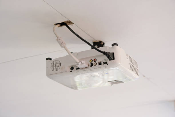 istock White projector hanging on the ceiling of conference room. 862514682