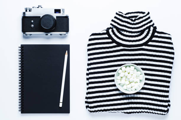 Striped women's blouse old camera and sketchbook on a white background
