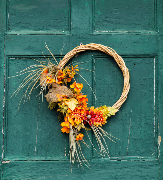An autumn or fall wreath decoration on a vintage green door