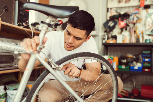 Man bicycle mechanic repairing bicycles
