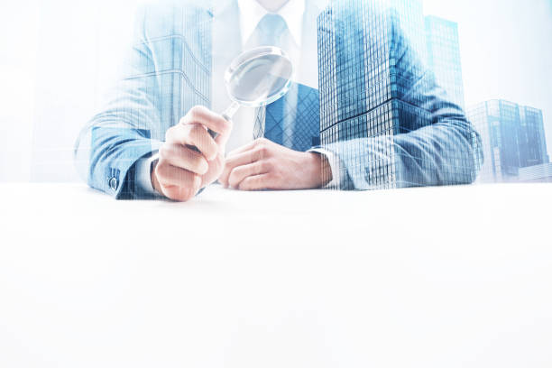 istock Businessman Holding a Magnifying Glass with Double Exposure Cityscape 862531928