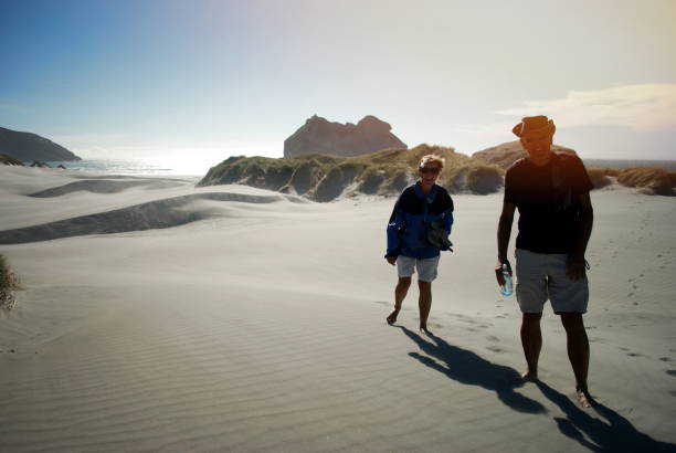 senior pareja riendo en una playa - golden bay fotografías e imágenes de stock