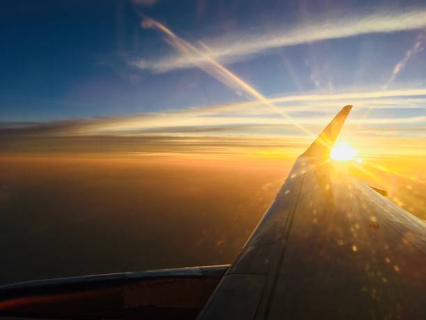 istock sun setting in the sky along the plane wing 862534810