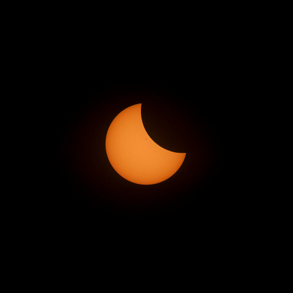 The moon starts to appear in front of the sun as the eclipse begins.