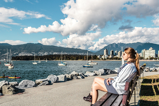 Photo of Girl Sitting on a Bench at Kitsilano Beach in Vancouver, Canada
