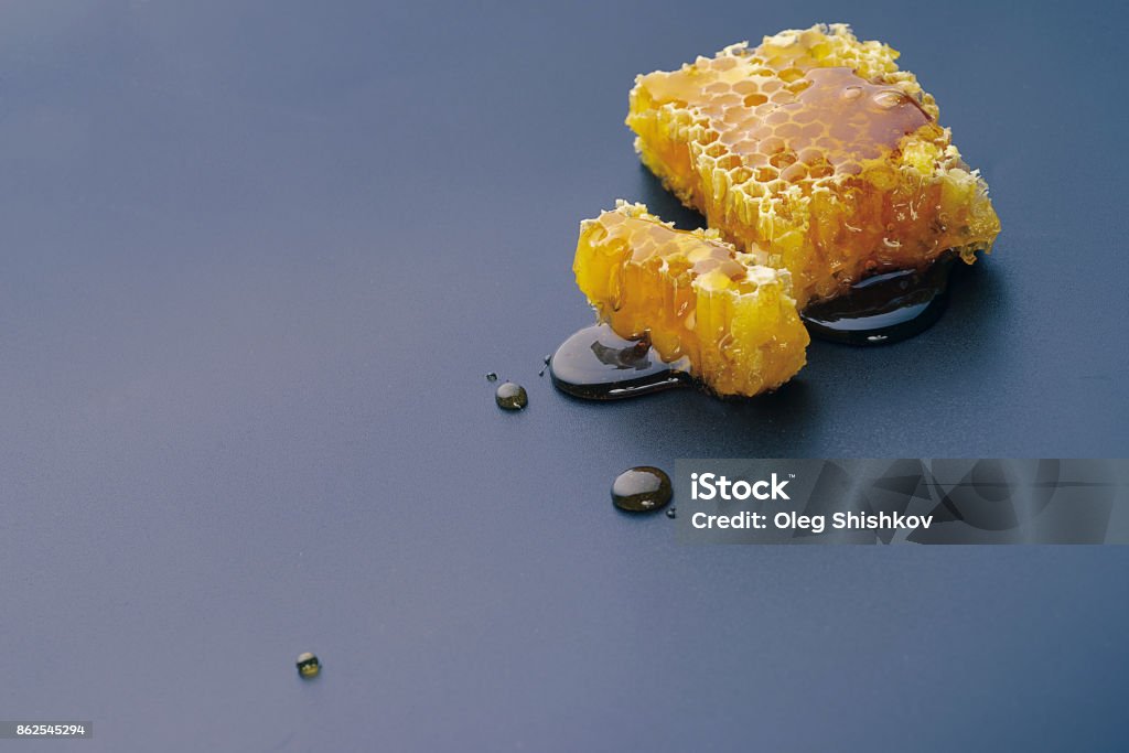 Honeycombs on a black background honey bee flows out of honeycomb on a black background Beehive Stock Photo