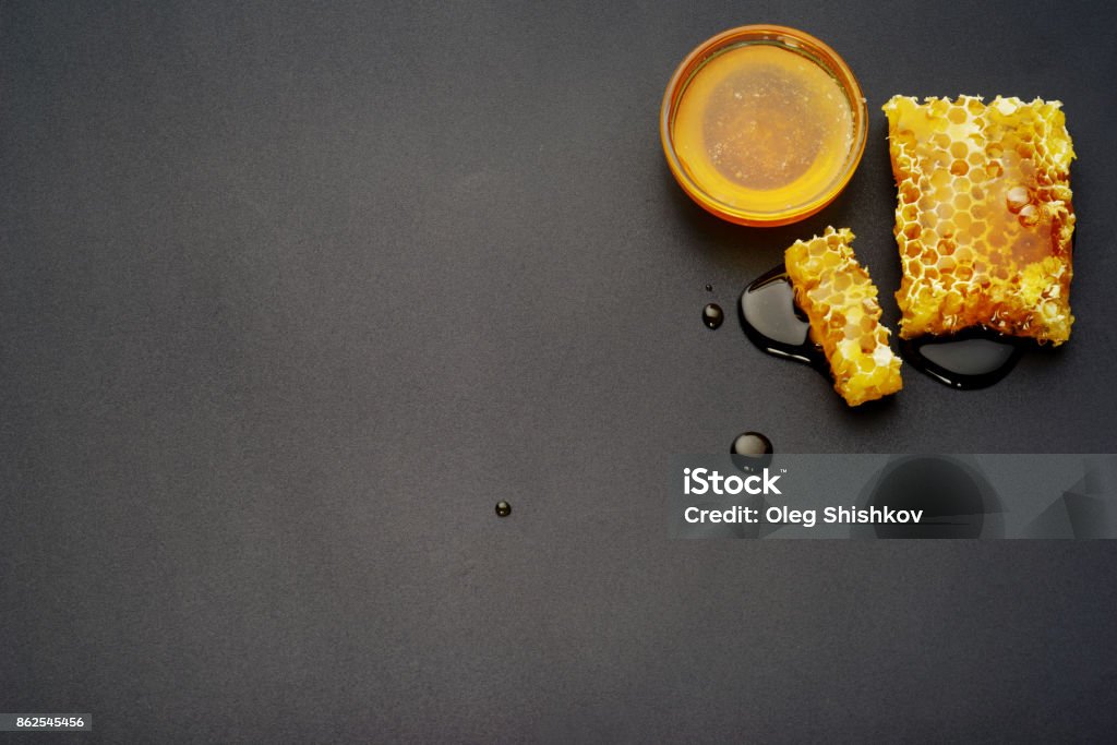 Honeycombs on a black background top view, honey bee flows out of honeycomb on a black background Beehive Stock Photo