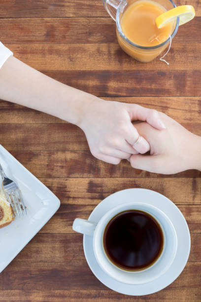 istock High angle view of couple holding hands in coffee shop 862546292